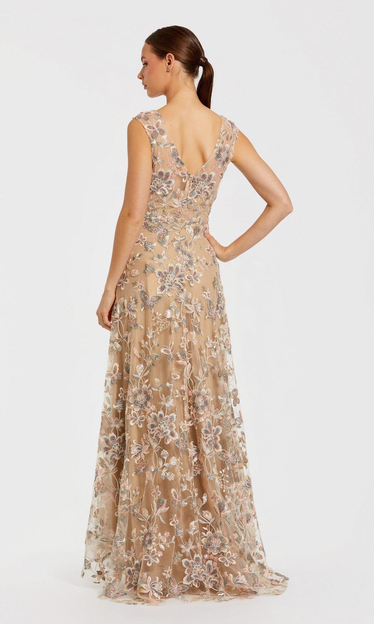 A woman is seen from the back against a plain white background, wearing the Long Formal Dress: Mac Duggal 68907—a tan, floor-length evening gown adorned with floral lace embroidery for an elegant look.